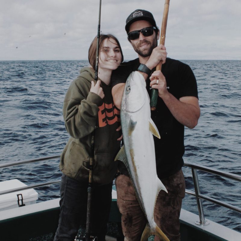 a man and a woman standing next to a body of water