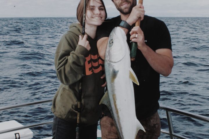 a man and a woman standing next to a body of water