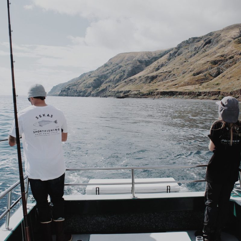 a man standing next to a body of water