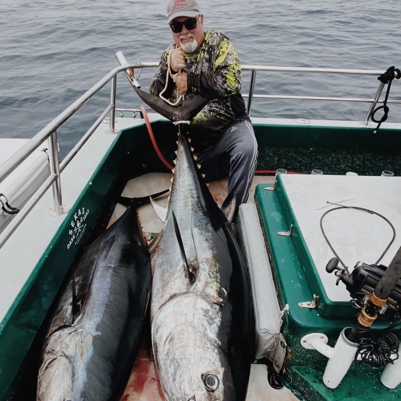 a person holding a fish on a boat in the water