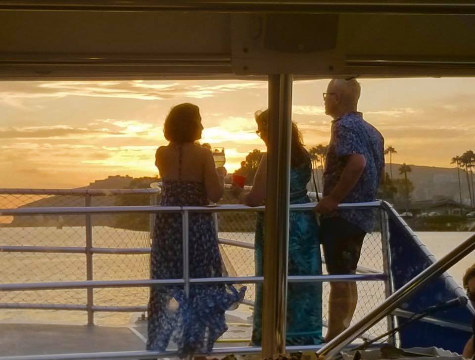 Guests watching the sunset from the deck of a Dana Wharf boat
