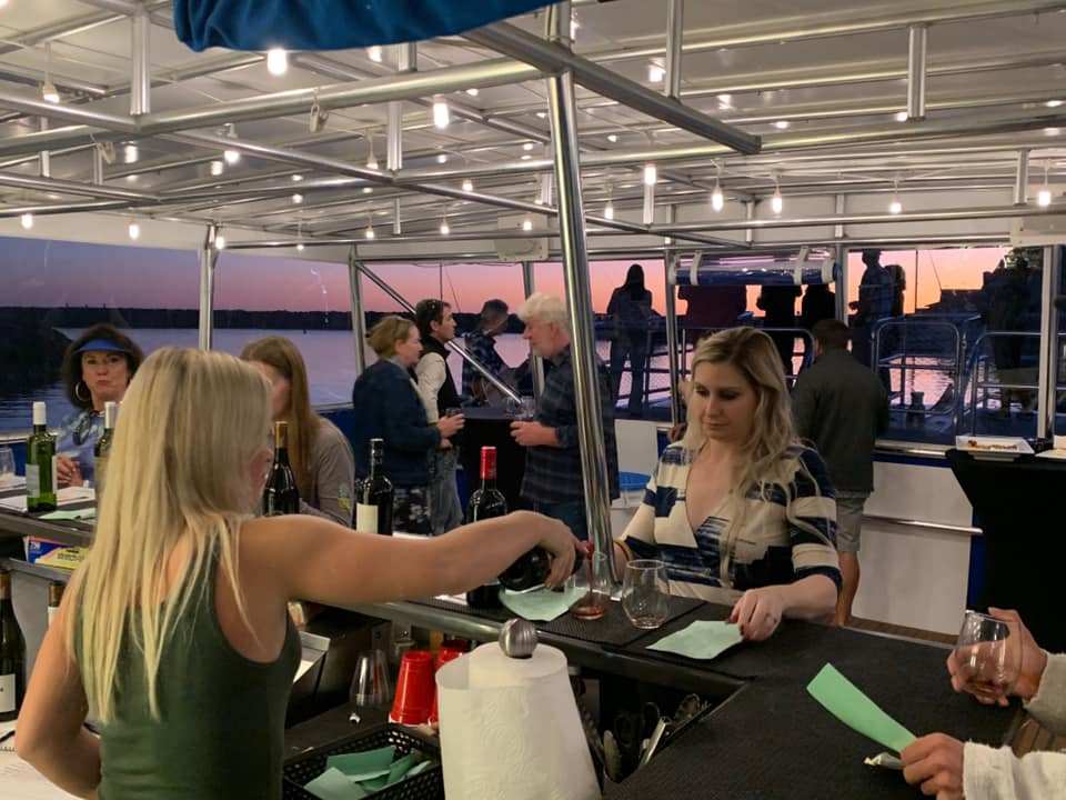 Guests at the wine bar on deck during the evening wine cruise in Dana Point Harbor