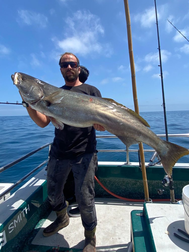 a man holding a fish in the water