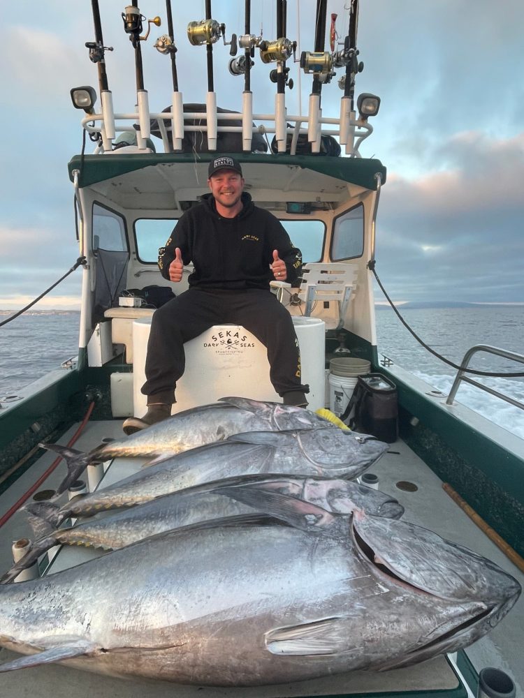 a man holding a fish on a boat