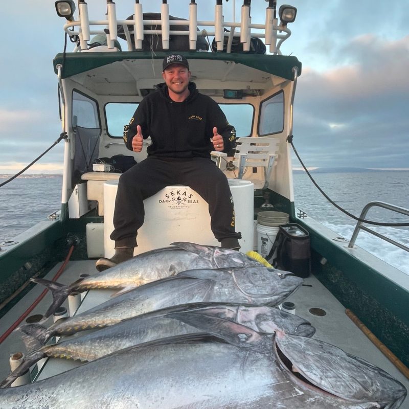 a man holding a fish on a boat