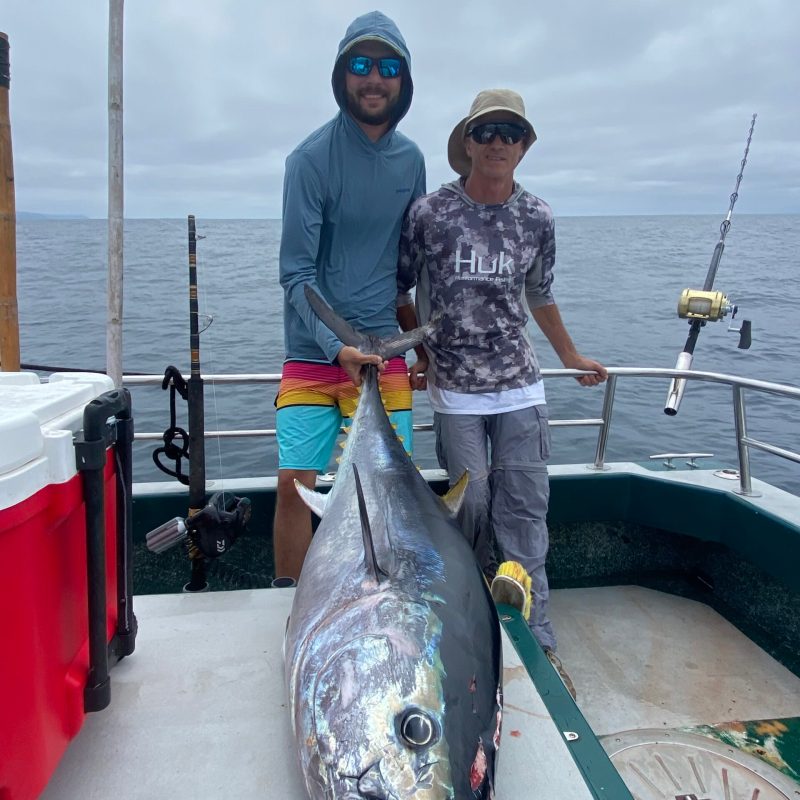 a man holding a fish on a boat