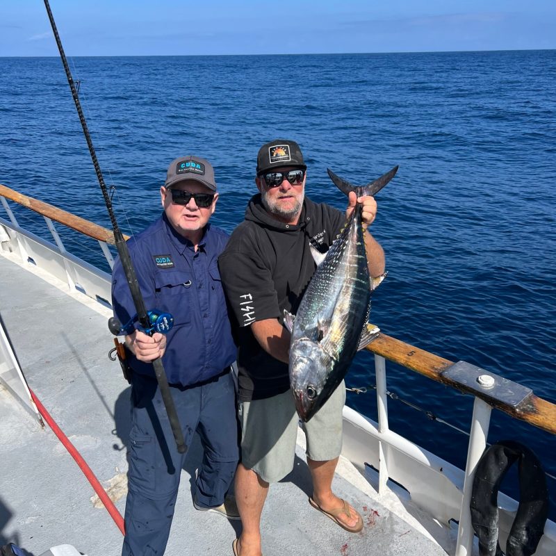 a person holding a fish on a boat in the water