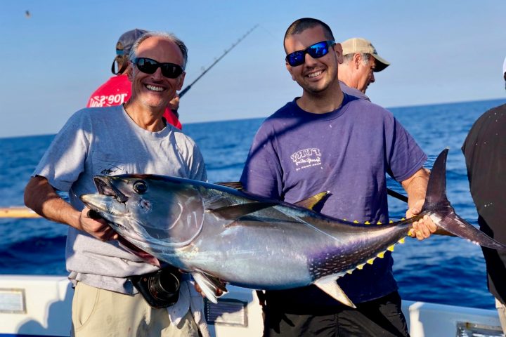 a man holding a fish in the water