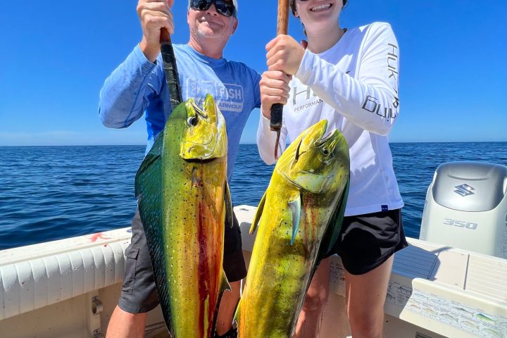 a person holding a fish on a boat