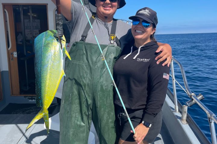 a person holding a fish on a boat