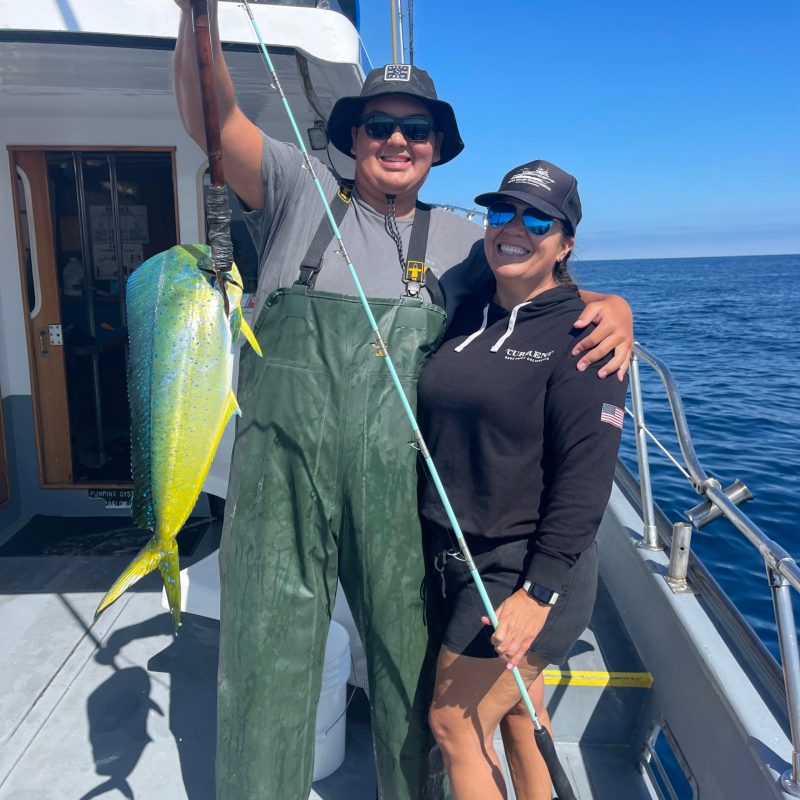 a person holding a fish on a boat