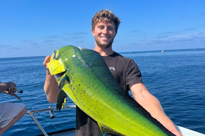 a man standing next to a body of water