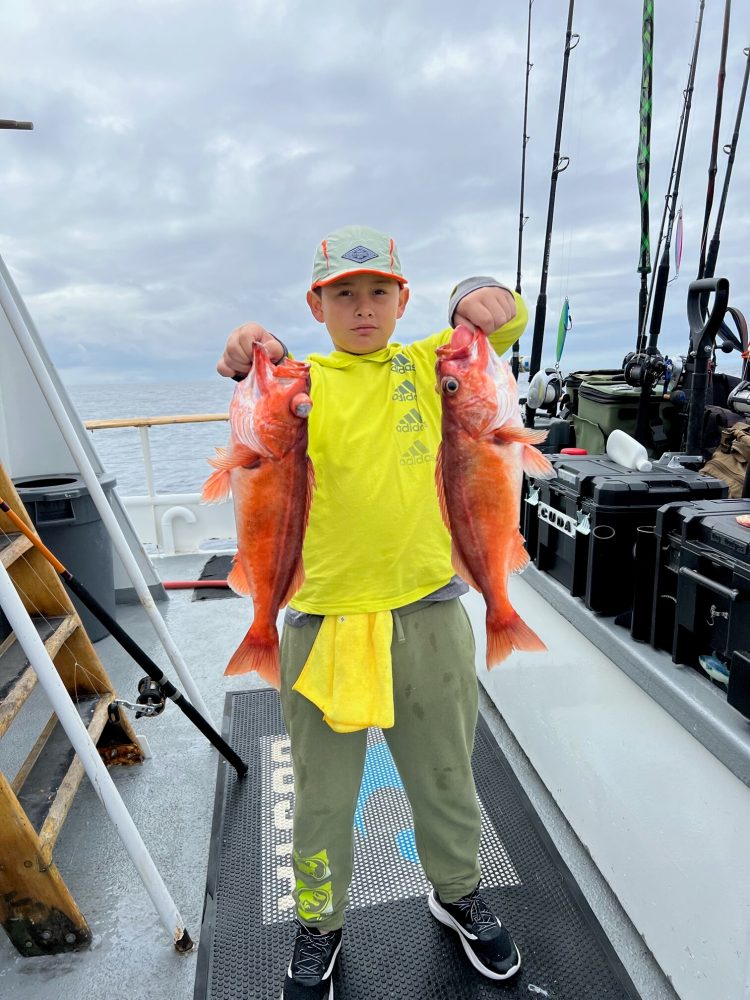 a man holding a fish on a boat