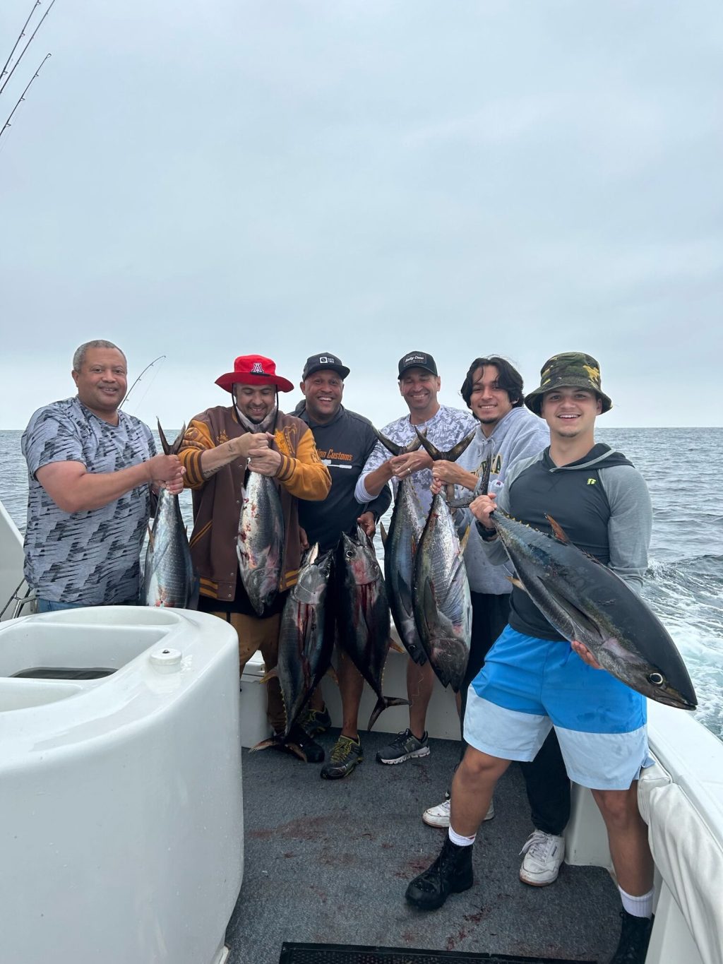 a group of people standing next to a person holding a fish