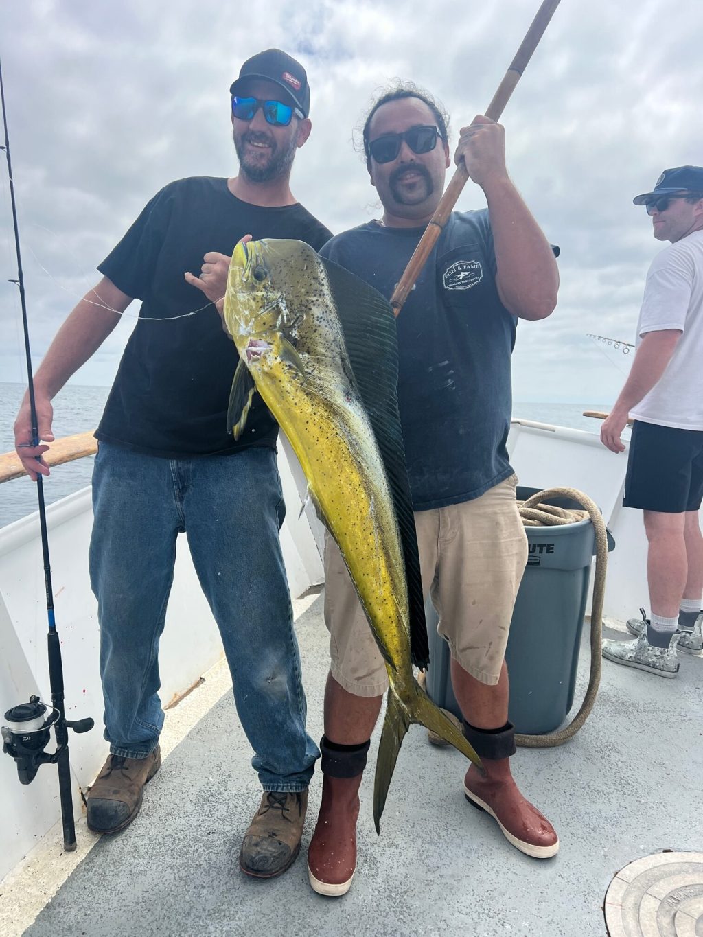 a group of people standing next to a person holding a fish