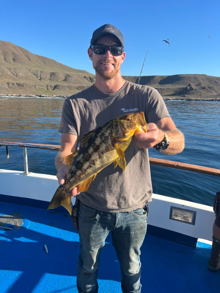 a man holding a fish in the water