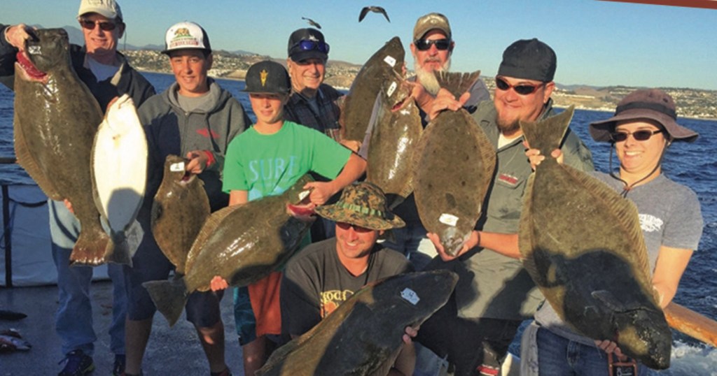 a group of people standing next to a person holding a fish