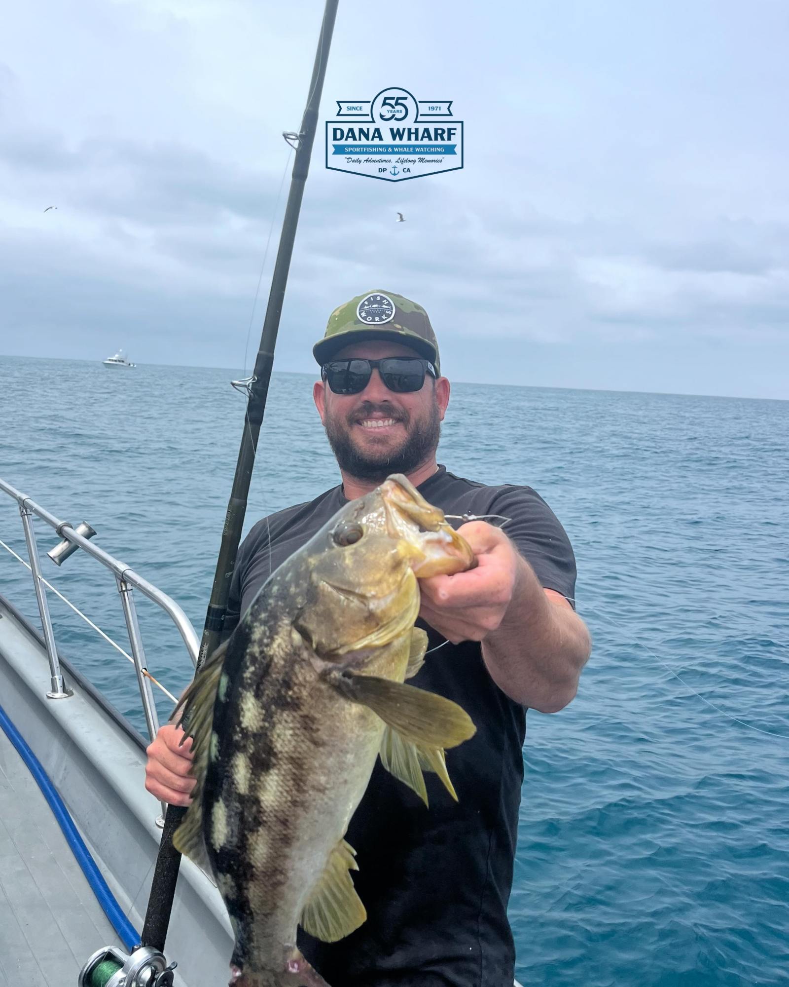 Angler holding a calico bass aboard a Dana Wharf sportfishing trip off Dana Point