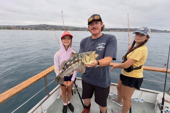 Family with a calico bass on a Dana Wharf half-day fishing trip from Dana Point