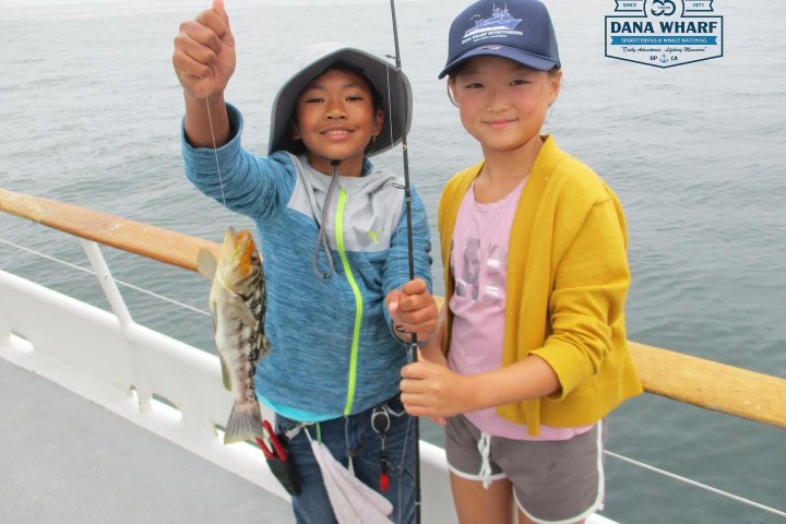 Two young anglers with a bass at the Dana Wharf kids fishing camp
