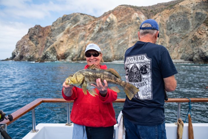 Angler with their catch on a Dana Wharf overnight fishing trip out of Dana Point
