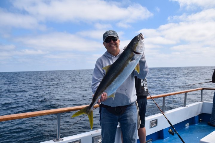 Angler with their catch on a Dana Wharf overnight fishing trip out of Dana Point