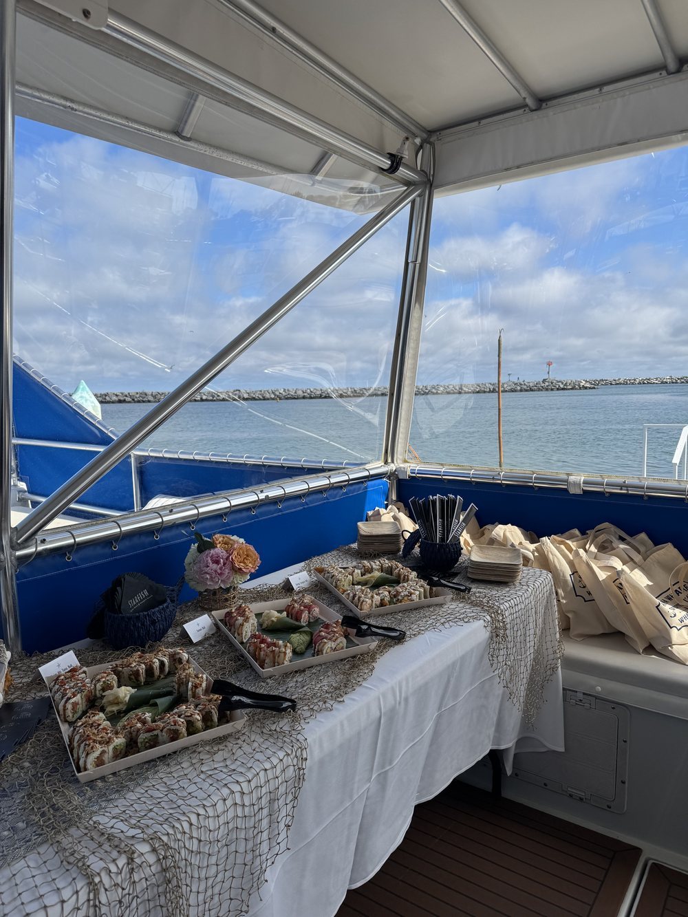 Event buffet on the deck of a Dana Wharf catamaran with Dana Point Harbor behind